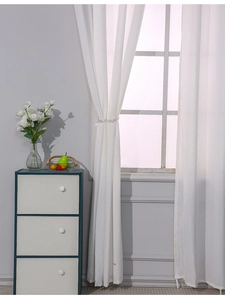 Close-up of white semi-transparent outdoor curtain with elegant beaded curtain tieback