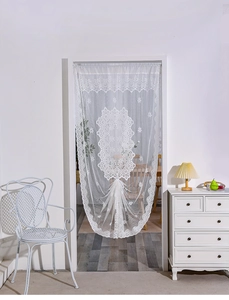 Close-up of white lace door curtain with intricate floral mesh and scalloped edges