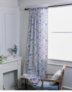 Detailed view of ocean-themed curtains with hand-drawn blue marine prints and tassel fringe