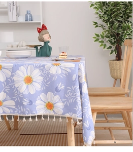 Detail of purple tablecloth with white daisies, cotton linen texture and tassel fringe
