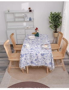Detail of nautical linen tablecloth featuring blue sea life prints and white tassel edges