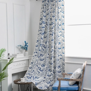 Bohemian blue floral curtains with elephant patterns and cream tassels in bright room