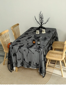 Detail of black Halloween lace tablecloth with skull bat and spider web patterns