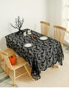 Detail of Halloween black lace tablecloth with bat and pumpkin patterns on wood table