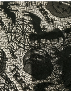 Close-up of black Halloween lace fabric featuring spider webs, bats and Trick or Treat motifs