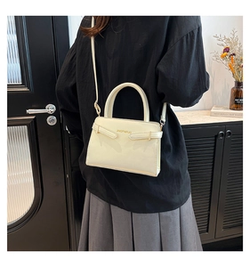 Vue détaillée du sac à main en cuir blanc crème montrant sa forme boxy et son profil