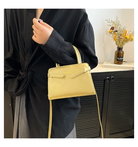 Détail du mini sac carré vert citron en cuir avec poignée et logo en relief