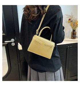 Vue détaillée du sac en cuir doré champagne avec boucle décorative et bandoulière réglable
