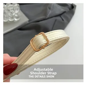 Détail de la bandoulière réglable en cuir avec boucle dorée et coutures précises