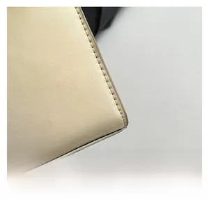 Détail macro du cuir blanc crème avec des coutures précises et une texture de qualité