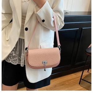 Détail du sac selle rose à motif crocodile avec fermoir rotatif argenté et gland chic