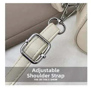 Détail de la bandoulière réglable avec boucle argentée sur un sac à main beige