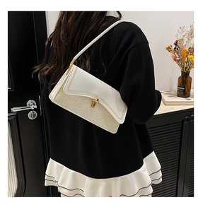 Detail of white sequin patchwork bag featuring gold chain trim and rectangular twist lock