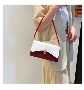 Detailed view of the contrast color shoulder bag with sequins on a beige suit outfit