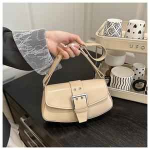 Detailed shot of beige PU leather baguette bag with silver buckle in a lifestyle setting