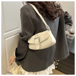 Detailed view of off-white shoulder bag with vintage silver buckle and leather texture