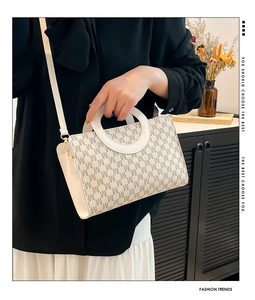Detail of cream crossbody bag with M-letter jacquard pattern and large round handle