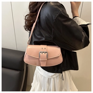 Detailed close-up of a pink leather saddle bag with silver buckle worn by a model