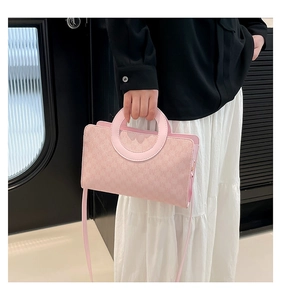 Detail of pink faux leather crossbody bag with round handle and monogram texture