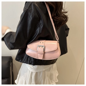 Detailed side view of a pink patent leather baguette bag with a large metallic buckle