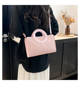 Detail of pink faux fur crossbody bag with round handle and leather trim on model
