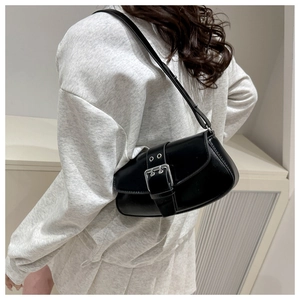 Close-up of vintage black crossbody bag with large metallic buckle and adjustable strap