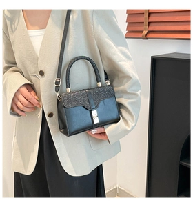 Detail of black PU leather handbag featuring a glittering sequin flap and gold metal lock