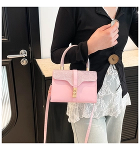 Detail of pink sequin crossbody bag with gold twist lock and rounded top handle