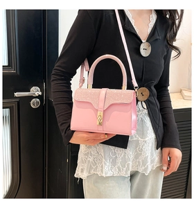 Pink glitter luxury crossbody handbag with gold twist lock shown on a model