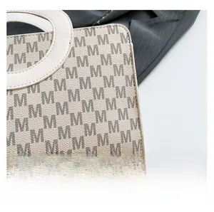 Close-up of premium fabric with M-pattern monogram and unique circular cutout handle