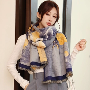 Close-up of winter scarf with floral prints and tassel edges on female model