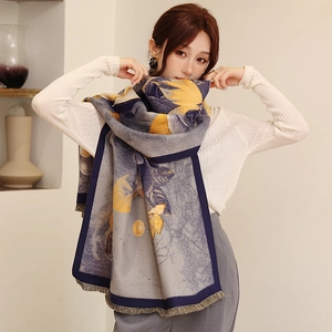 Close-up of winter faux cashmere scarf with yellow floral print and fringe details