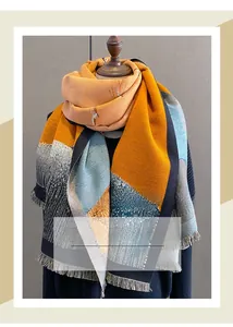 Detailed view of thick patchwork shawl with tassels on a mannequin for autumn winter