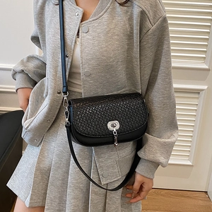 Sacoche selle noire tressée à la mode avec tenue décontractée grise pour un look chic
