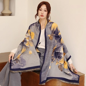 Detail of elegant pashmina shawl with yellow and purple floral pattern and fine fringes