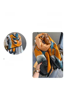 Detail view of the soft faux cashmere scarf featuring vibrant orange and teal deer patterns
