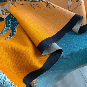 Macro shot of thick winter scarf featuring double-sided floral jacquard and bird patterns