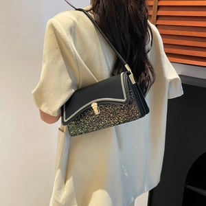 Black patchwork shoulder bag with colorful sequins and golden lock on a female model