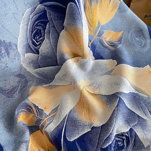 Macro shot of faux cashmere scarf with large rose patterns and silk-like woven texture