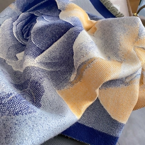 Macro view of navy and yellow rose jacquard knit cashmere-like scarf texture