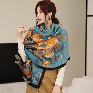Détail de l'écharpe effet cachemire bleu sarcelle avec motifs orange et fines franges