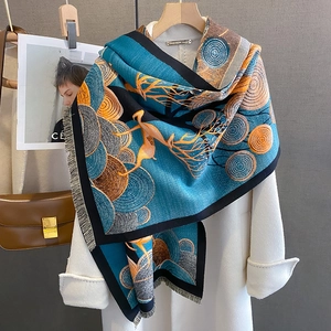 Écharpe motif élan bleu lac et orange aspect cachemire avec franges sur manteau