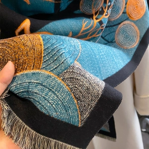 Gros plan d'une écharpe d'hiver avec motifs de montagne abstraits et détails de franges