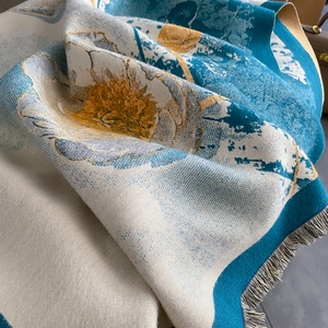 Détail d'un châle vintage en cachemire avec des motifs floraux jaunes et de fines franges