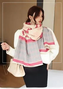Detail of pink and beige cashmere-like scarf with floral and diamond patterns