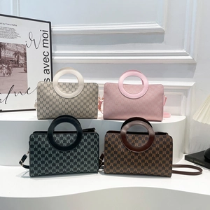 Retro monogrammed leather handbag with unique circular cutout handles in four colors