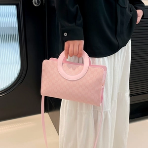 Pink minimalist crossbody bag with iconic round handle and textured surface for women
