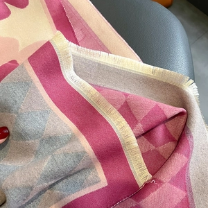 Detailed close-up of thick cashmere-like scarf showing fringe edges and geometric patterns