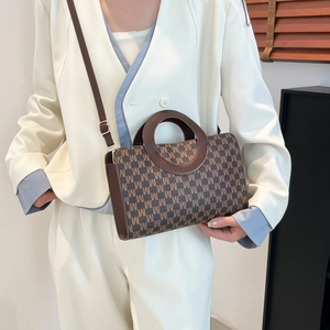 Brown monogram small square bag with round handles and crossbody strap on white suit model