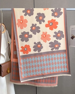 Detail showing the floral pattern, geometric diamonds, and tassels on the cashmere scarf